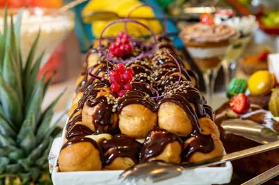 a chocolate cake with fruit on top of it at King Jason Protaras - Designed for Adults by Louis Hotels in Protaras