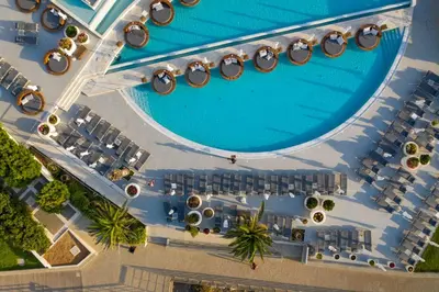 an overhead view of a pool with a lot of tables and chairs at King Jason Protaras - Designed for Adults by Louis Hotels in Protaras