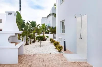a white house with a courtyard with palm trees at Villa Katherine - Nissi Beach Area in Ayia Napa