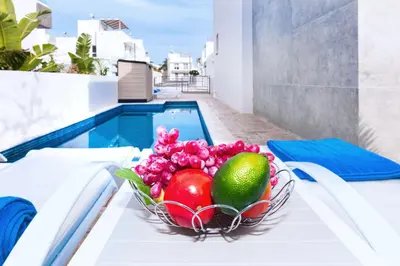 a bowl of fruit on a table next to a pool at Villa Katherine - Nissi Beach Area in Ayia Napa