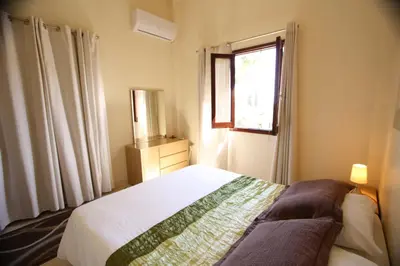 a bedroom with a white bed and a window at Apokryfo, one bedroom apartment close to the beach in Pissouri