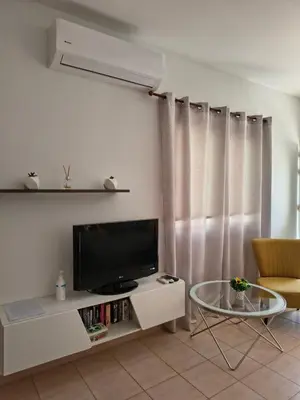 a living room with a television and a table at SUNNY HOME in Protaras