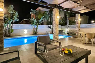 a swimming pool in a house with a table and chairs at Villa Anastasia - Fig Tree Bay Area in Protaras