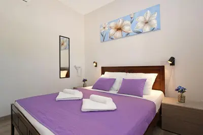 a bedroom with a purple bed with two towels on it at Villa Anastasia - Fig Tree Bay Area in Protaras