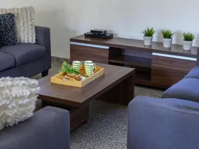 a living room with a coffee table and two chairs at Protaras Villa Theodora 1 in Protaras