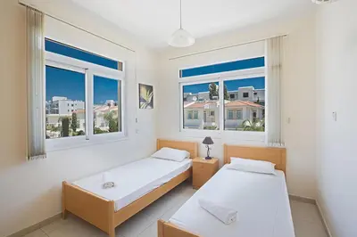 two beds in a room with two windows at Protaras Villa Theodora 27 in Protaras