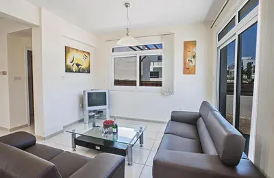 a living room with a couch and a glass table at Protaras Villa Theodora 27 in Protaras
