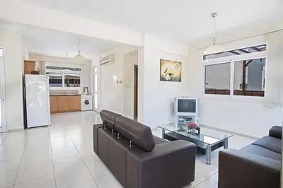 a living room with a couch and a table at Protaras Villa Theodora 27 in Protaras