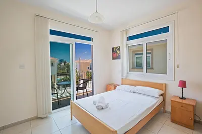 a bedroom with a bed and a large window at Protaras Villa Theodora 27 in Protaras