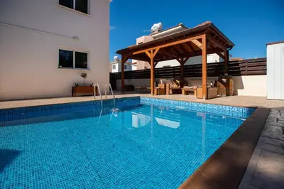 a swimming pool with a gazebo next to a building at STAY Villa Anemone in Protaras