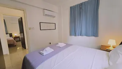 a bedroom with a white bed with two towels on it at STAY Villa Anemone in Protaras