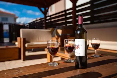 a bottle of wine sitting on a table with two glasses at STAY Villa Anemone in Protaras