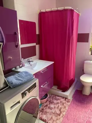 a bathroom with a pink shower curtain and a sink at My Holiday in Ayia Napa