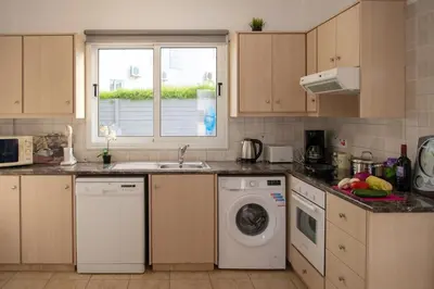 a kitchen with a sink and a washing machine at Villa Ruby Evelyn in Protaras