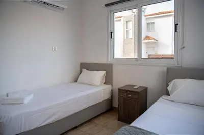 two beds in a small room with a window at Villa Ruby Evelyn in Protaras