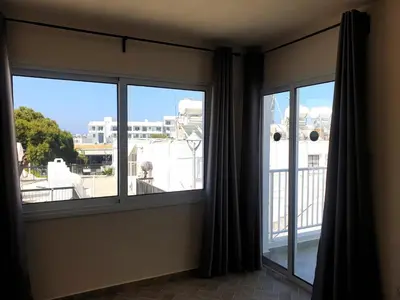 two windows in a room with a view of a building at Leucolla Hill & Sea in Protaras