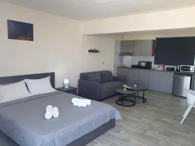 a bedroom with a bed and a couch and a kitchen at Leucolla Hill & Sea in Protaras