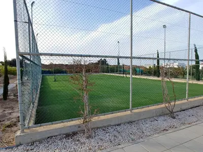a chain link fence with a soccer field behind it at AP10 Mythical Sands in Protaras