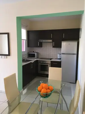 a kitchen with a bowl of oranges on a glass table at AP10 Mythical Sands in Protaras