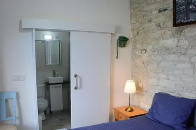 a bedroom with a bed and a stone wall at Lazaros Stonehouse in Pano Lefkara