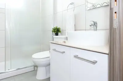 a white bathroom with a toilet and a sink at Villa Ivory - Seafront in Ayia Napa