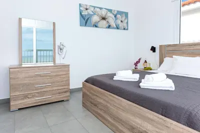 a bedroom with a large bed and a mirror at Villa Ivory - Seafront in Ayia Napa