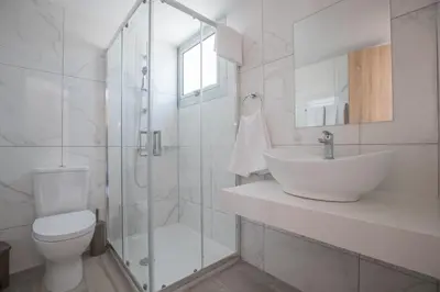 a bathroom with a toilet and a sink and a shower at Bohemian Gardens Hotel in Protaras