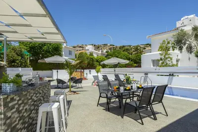 a patio with a table and chairs and a building at Villa Alleli in Protaras