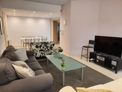 a living room with a couch and a table and a television at 3 Bedroom Apartment in Nicosia
