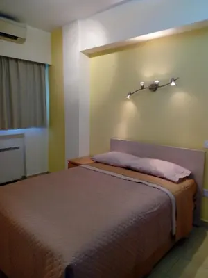 a bedroom with a bed with a light on the wall at 3 Bedroom Apartment in Nicosia