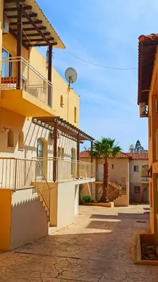 a street in a town with buildings and a palm tree at Holidays in Cyprus in Ayia Napa