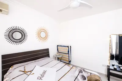 a bedroom with a bed and a mirror on the wall at Lovely 2 BR Vacation Apt Kohili Beach - 3 Min Walk in Paralimni