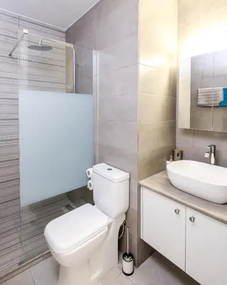 a bathroom with a white toilet and a sink at Lovely 2 BR Vacation Apt Kohili Beach - 3 Min Walk in Paralimni