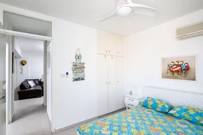 a bedroom with a bed and a ceiling fan at Lovely 2 BR Vacation Apt Kohili Beach - 3 Min Walk in Paralimni