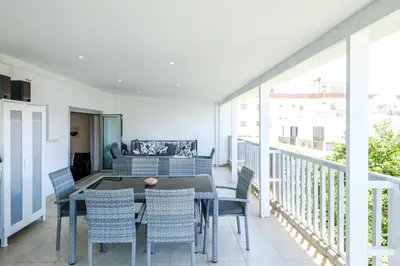 a dining room with a table and chairs on a balcony at Lovely 2 BR Vacation Apt Kohili Beach - 3 Min Walk in Paralimni