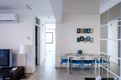 a white living room with a table and chairs at Lovely 2 BR Vacation Apt Kohili Beach - 3 Min Walk in Paralimni