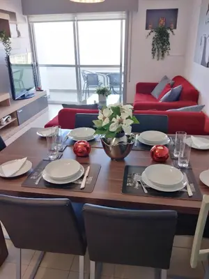 a dining room table with white plates and red chairs at Amazing Sea Place in Limassol