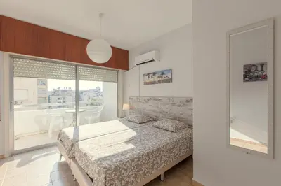 a bedroom with a bed and a large window at Furnished Seafront Studio in Larnaka