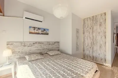 a white bedroom with a bed in a room at Furnished Seafront Studio in Larnaka