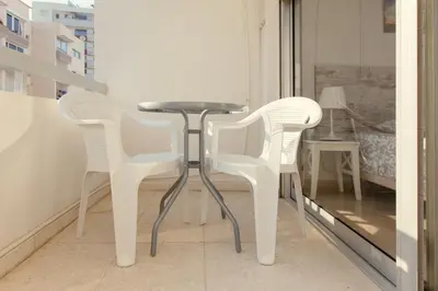 two white chairs and a table on a balcony at Furnished Seafront Studio in Larnaka