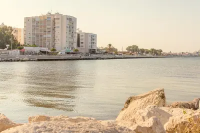 a large body of water with buildings in the background at Furnished Seafront Studio in Larnaka