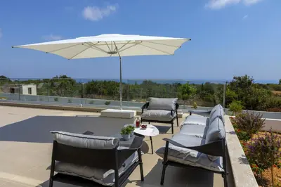 a patio with chairs and an umbrella on a roof at Villa Elite in Protaras