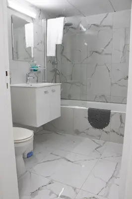 a white bathroom with a toilet and a shower at Apartment,NEAR THE BEACH Pinikoudes in Larnaka