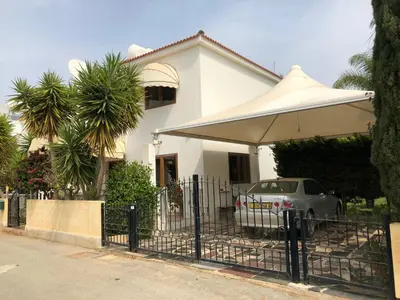 a car parked in front of a house with an umbrella at Villa Natalia in Ayia Napa