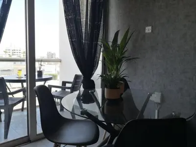 a dining room with a glass table and chairs at Loizou Holdings Flat 301 in Larnaka