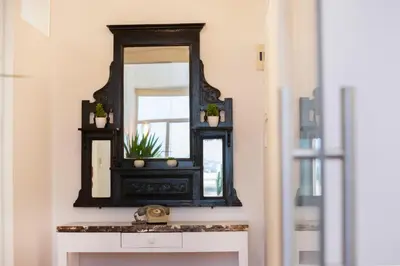 a mirror on a wall above a white dresser at 1-80 Collection by TrulyCyprus in Limassol