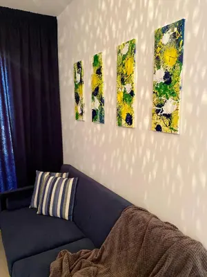 a living room with a couch and four paintings on the wall at Fat Cow Apartment 102 in Livadhia