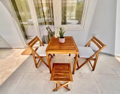 a wooden table with two chairs and a potted plant at The Courtyard Episkopi Guest Houses in Episkopi Lemesou