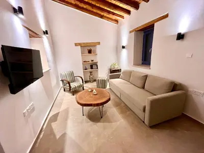 a living room with a couch and a table at The Courtyard Episkopi Guest Houses in Episkopi Lemesou