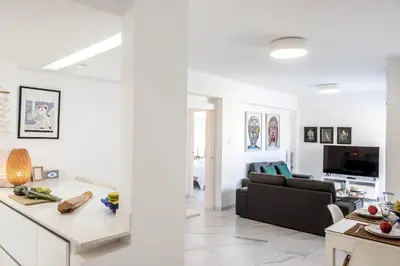 a white living room with a couch and a table at Mackenzie Leo Seafront Suite in Larnaka